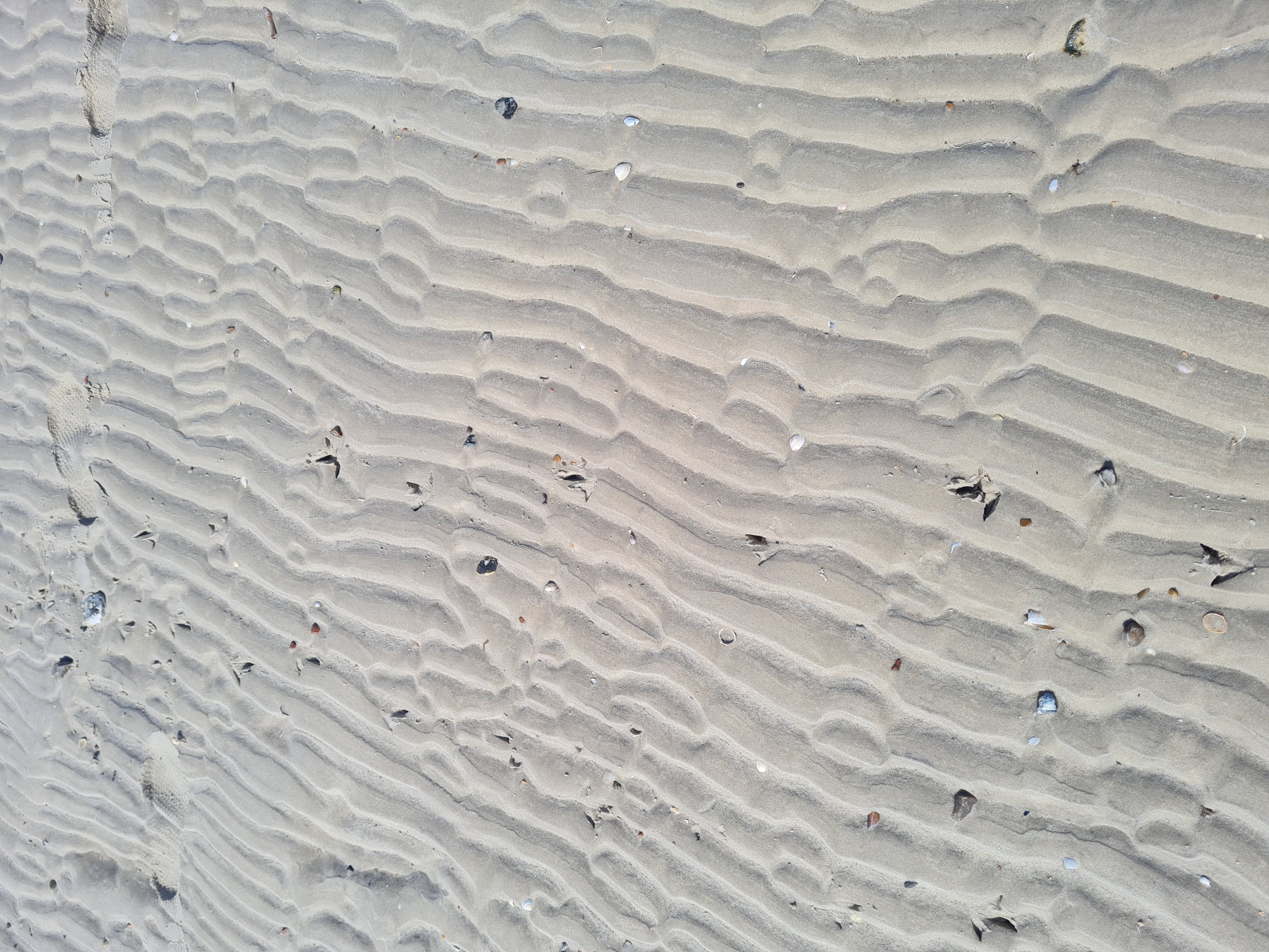 photo of the patters in the sand caused by the waves