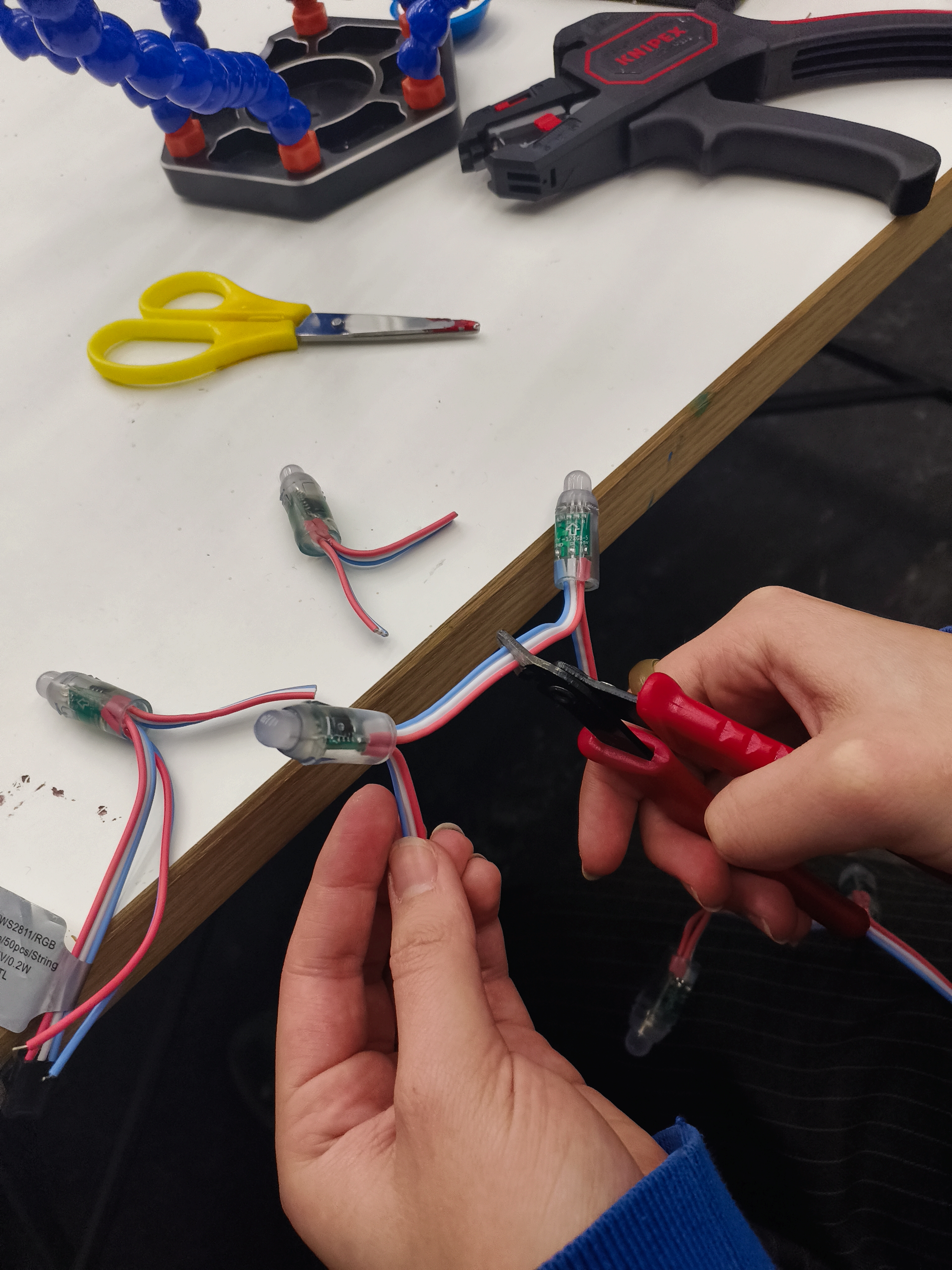 Hier wird ein Kabel zwischen zwei LEDs zerschnitten